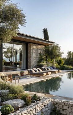 an outdoor swimming pool with chaise lounges next to it