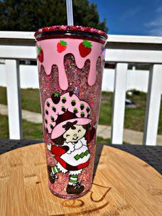 a pink cup sitting on top of a wooden table