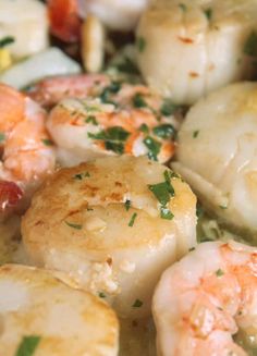 shrimp and scallops in a white sauce with parsley sprinkled on top