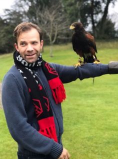 a man is holding a bird on his arm