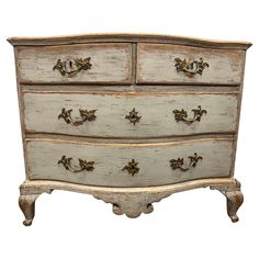 an old chest of drawers is painted white and has gold hardware on the top drawer