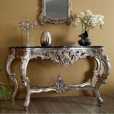 an ornate silver console table with flowers and candles