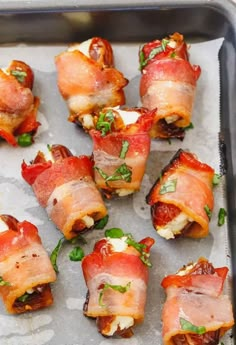 bacon wrapped in cheese and garnished with parsley on a baking sheet, ready to go into the oven