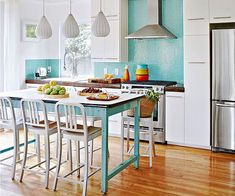 a kitchen with blue and white tile on the walls, counter tops, and chairs