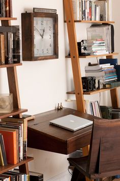 a wooden ladder leaning against a wall next to a desk with a laptop on it