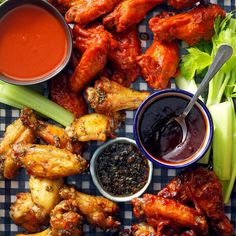 chicken wings, celery, and dipping sauces on a checkered tablecloth