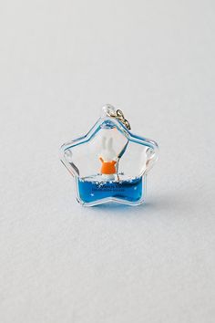 an ornament shaped like a boat floating in the ocean with water inside it