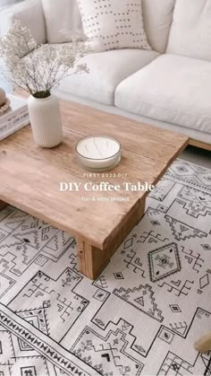 a coffee table sitting on top of a rug next to a white couch in a living room