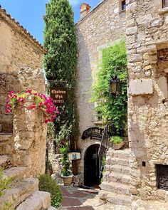 an alley way with stone buildings and flowers