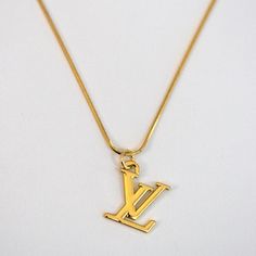 LV Logo Necklace Reluxe Vintage Lv Gold Necklace, Luxury Yellow Gold Necklace With Vintage Charm, Vintage Gold-tone Necklace With Logo Charm, Luxury Charm Necklaces With Logo, Pendant Necklace With Logo Charm For Gift, Logo Charm Pendant Necklace For Gift, Gift Pendant Necklace With Logo Charm, Vintage Yellow Gold Jewelry With Logo Charm, Vintage Gold-plated Tarnish-resistant Charm Necklaces