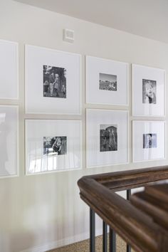 A white frame gallery wall with black and white photos. Wall Picture Frame Ideas Living Room, Assorted Mirrors On Wall, Top Of Stairway Wall Decor, Frame Pictures On Wall, End Of Hall Gallery Wall, Corner Gallery Wall With Chair, Large Gallery Wall Hallway, Dining Room Gallery Wall Ideas Modern, Gallery Wall On White Walls