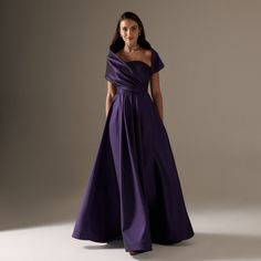 a woman in a long purple dress posing for the camera with her hands on her hips