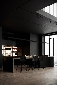 an empty dining room with black walls and wooden flooring is seen in this image