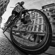 a man riding a bike down a street next to tall buildings