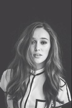 a black and white photo of a woman with long brown hair wearing a striped shirt