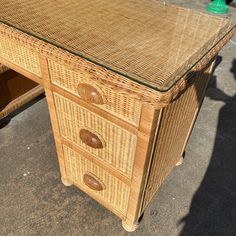 a wicker desk with two drawers on it