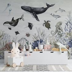 an ocean themed wallpaper with whale, corals and other marine life is featured in this children's room