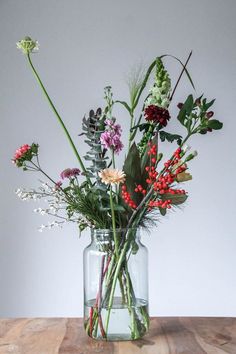 a vase filled with flowers on top of a wooden table