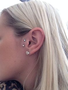 a woman with blonde hair wearing a pair of ear piercings