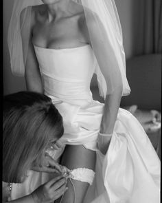 a woman in a wedding dress getting ready for her big day