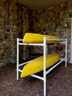 two yellow surfboards are sitting on a white rack in front of a brick wall