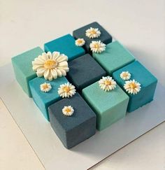 there is a cake made to look like blocks with flowers on them and one flower in the middle