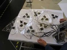 a person is working on an art project with wires and electrical components in the background