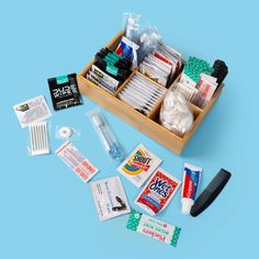 an assortment of medical supplies in a wooden box on a blue background, including toothpaste and dental floss