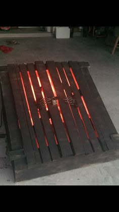 a fire pit made out of wood with red lights on it