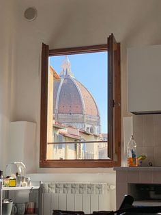 a kitchen with a stove top oven sitting under a window next to a wall mounted heater