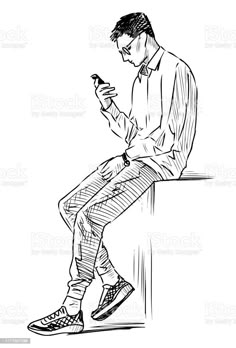 a man sitting on a ledge looking at his cell phone royalty - free stock photo