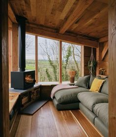 a living room filled with furniture and a fire place in front of a window that looks out onto the countryside