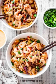 two bowls filled with shrimp and vegetables next to chopsticks on a white table