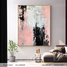 an abstract painting hangs on the wall above a couch in a white living room with black and pink accents