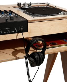 a turntable with headphones on it sitting next to a record player and mixer