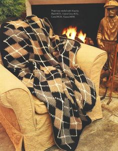 a couch with a blanket on it next to a fire place