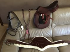 several different types of saddles and bridles on a couch