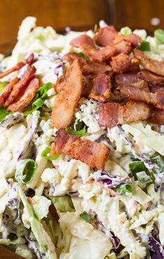 a salad with bacon, lettuce and other toppings on the side in a bowl