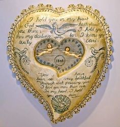 a heart shaped clock with two angels on it