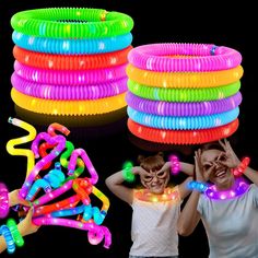 two girls standing next to each other in front of neon bracelets