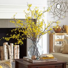 a living room filled with furniture and a fire place covered in yellow forsythia flowers