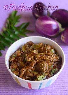 a bowl filled with meat and vegetables next to purple onions on a tableclothed surface