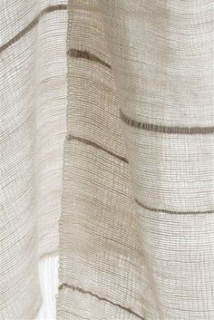 the back side of a white curtain with black lines on it and a brown stripe down the middle