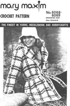 a woman in a coat and hat sitting on the ground