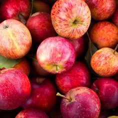 a pile of red and yellow apples sitting next to each other