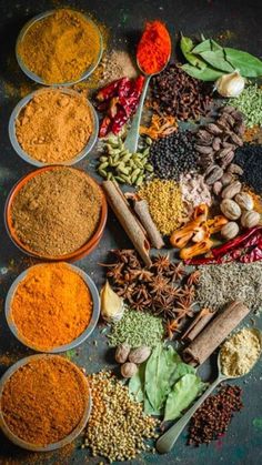 spices and herbs arranged in bowls on a table