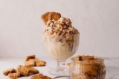 an ice cream sundae in a glass with cookies around it