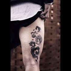 a person with a tattoo on their thigh and legs, holding onto the leg of another person