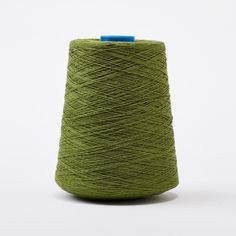 a spool of green yarn on a white background