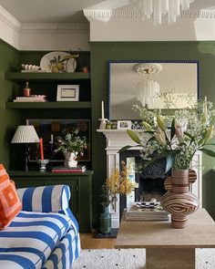 a living room filled with furniture and a fire place under a mirror next to a fireplace